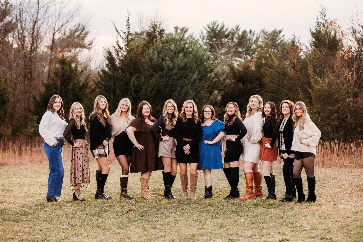 Women posing together outdoors in stylish outfits during fall season.